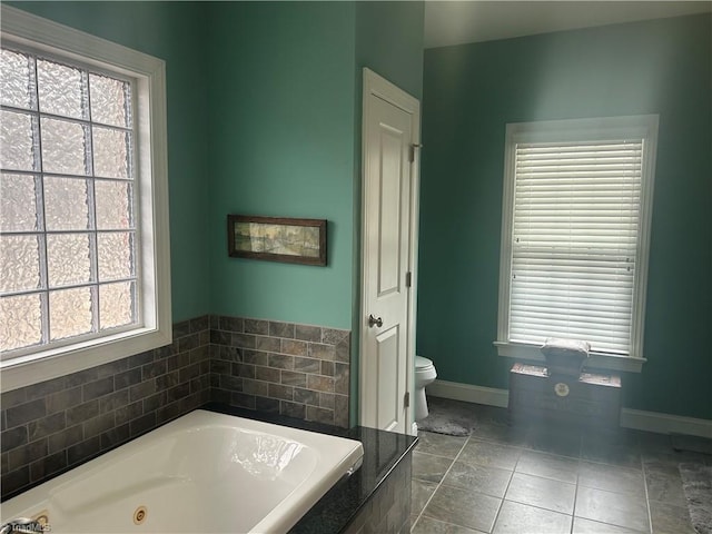 full bathroom with tile patterned flooring, plenty of natural light, toilet, and a tub with jets