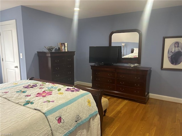 bedroom featuring baseboards and wood finished floors