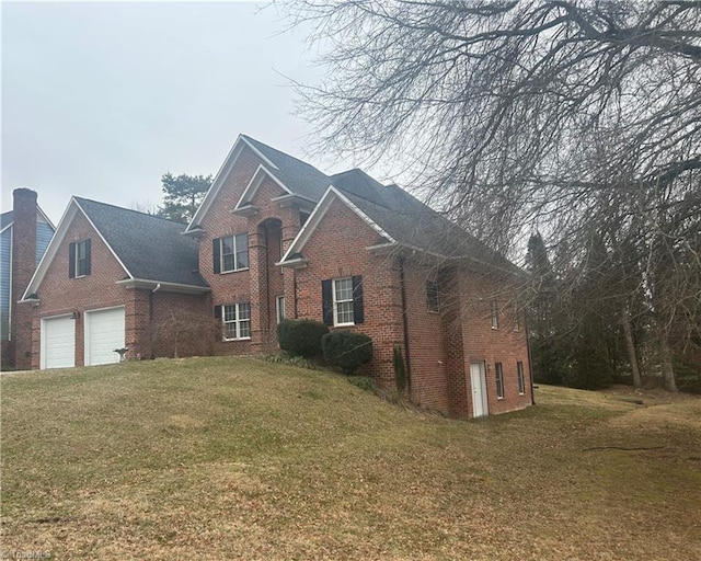 traditional home featuring a garage, a front lawn, and brick siding