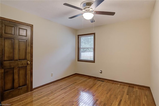 unfurnished room with baseboards, light wood-style floors, and a ceiling fan