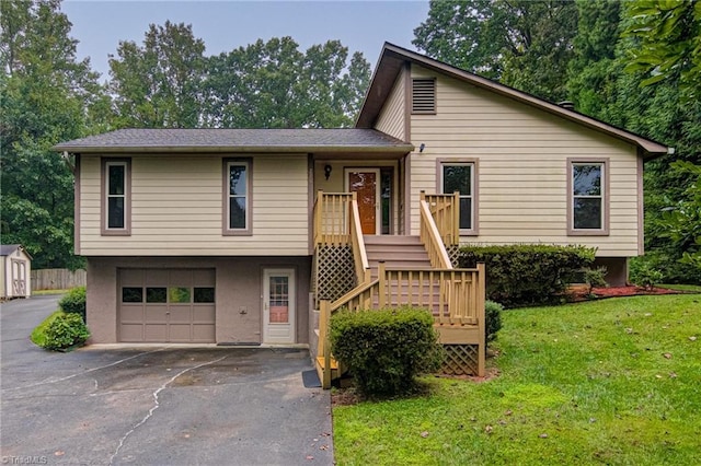 view of front facade with aphalt driveway, stairs, a front yard, stucco siding, and a garage