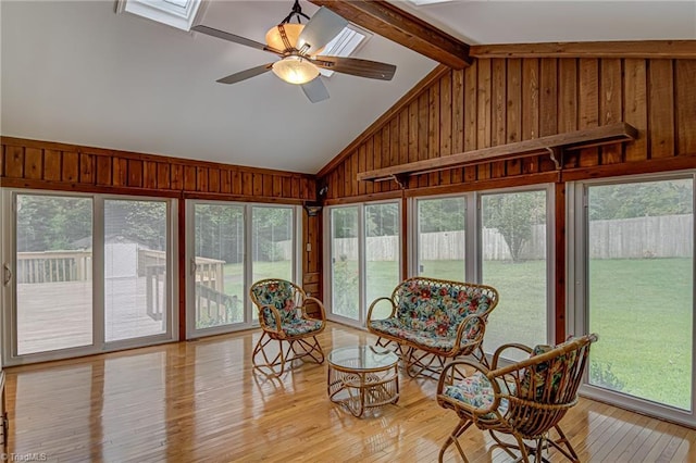 sunroom / solarium featuring a wealth of natural light, vaulted ceiling with skylight, and a ceiling fan