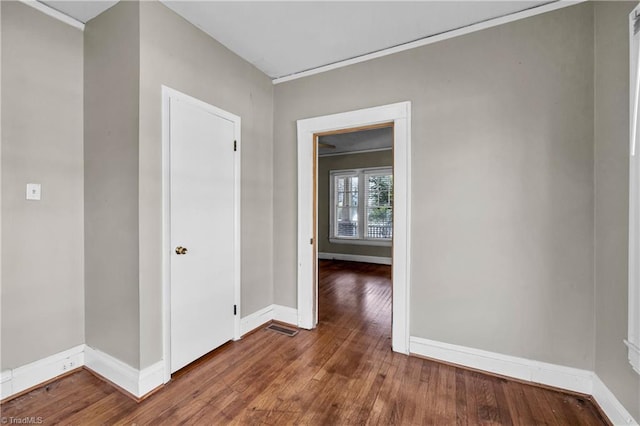 spare room featuring baseboards and wood-type flooring