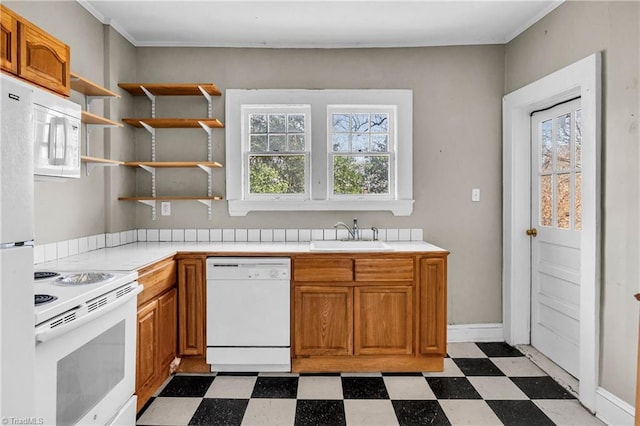 kitchen with a sink, brown cabinets, white appliances, and dark floors