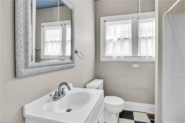 bathroom featuring tile patterned floors, baseboards, toilet, and vanity