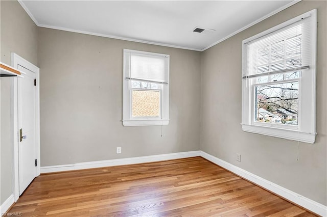 unfurnished bedroom with light wood-type flooring, visible vents, baseboards, and ornamental molding