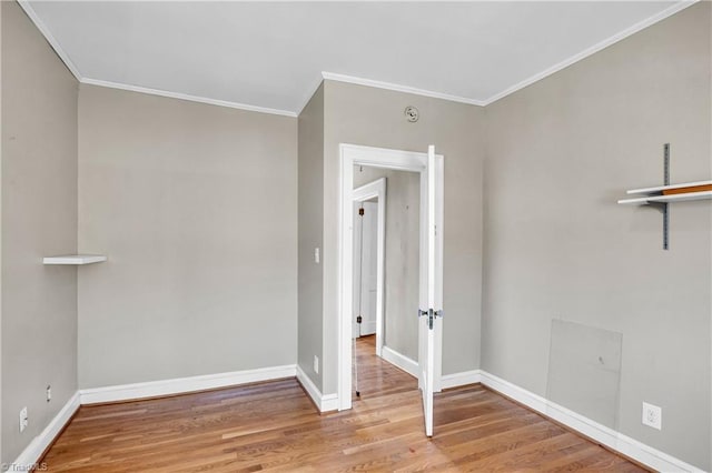 empty room with ornamental molding, baseboards, and wood finished floors