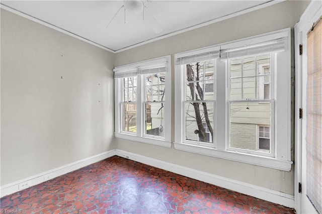 empty room featuring crown molding and baseboards