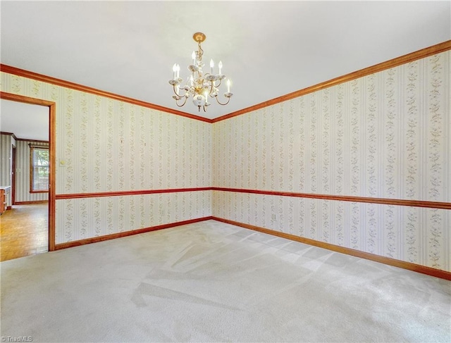 carpeted empty room featuring a notable chandelier and crown molding