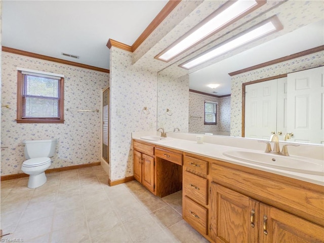 bathroom featuring ornamental molding, plenty of natural light, vanity, and toilet