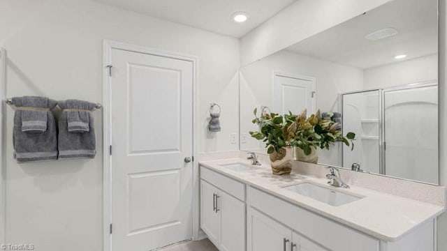 bathroom featuring vanity and a shower with door