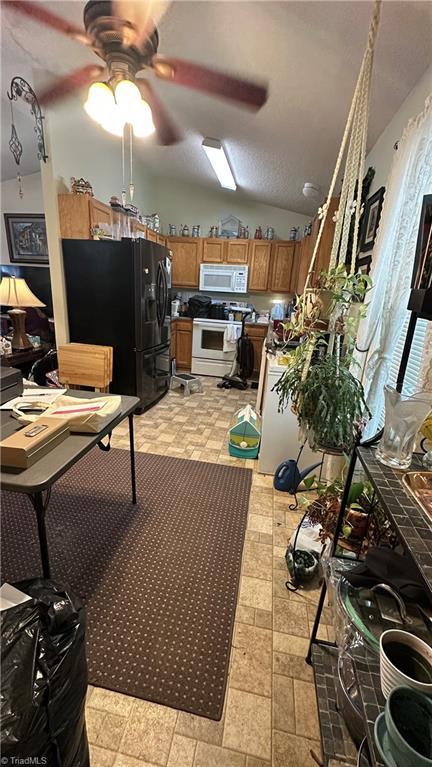 112 White St, Thomasville, NC 27360 - kitchen with white appliances, brown cabinetry, lofted ceiling, a ceiling fan, and light floors