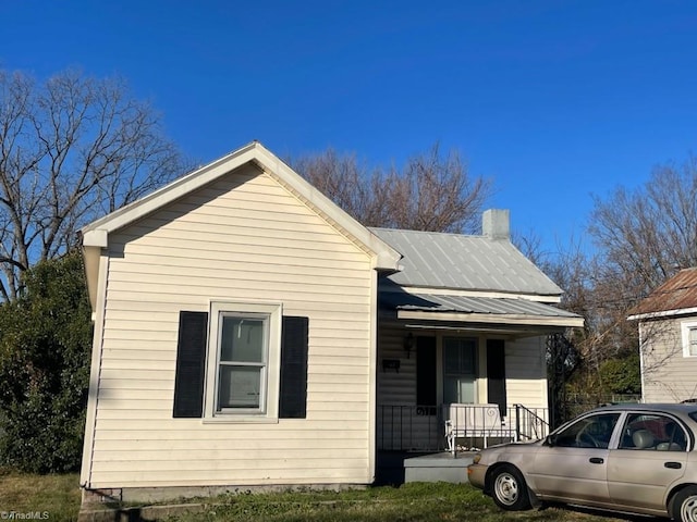 view of side of home featuring covered porch