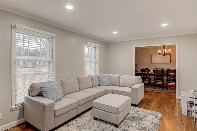 living room featuring ornamental molding, hardwood / wood-style floors, and an inviting chandelier