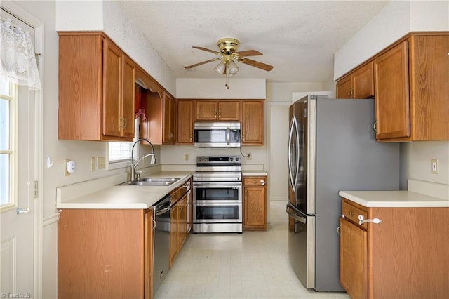 kitchen with sink, ceiling fan, appliances with stainless steel finishes, and a textured ceiling