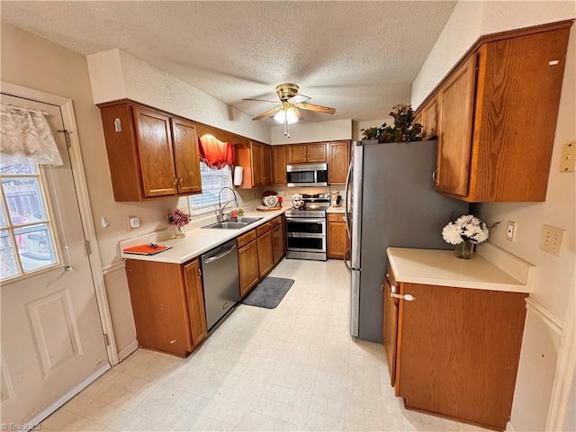 kitchen featuring sink, plenty of natural light, a textured ceiling, and stainless steel appliances