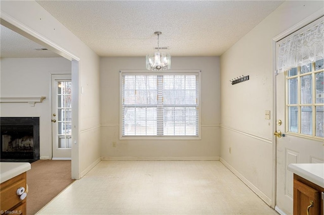 dining space featuring an inviting chandelier, plenty of natural light, and a textured ceiling