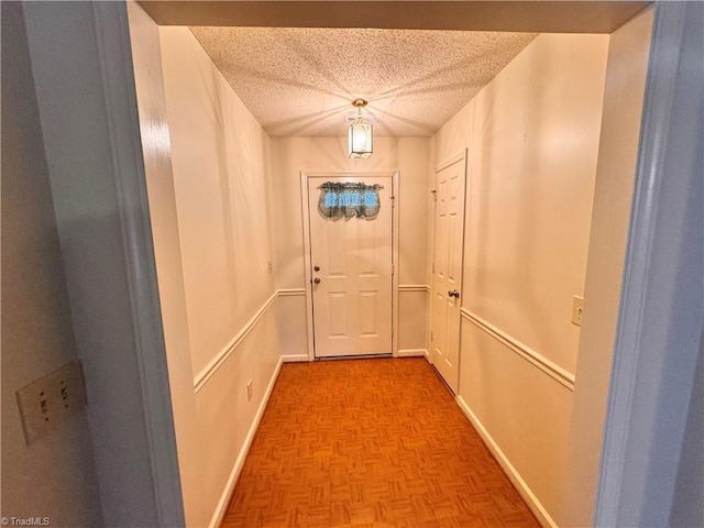 entryway featuring a textured ceiling and light parquet flooring