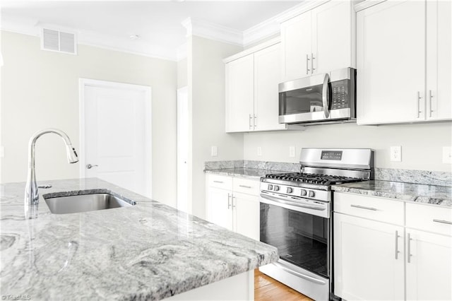 kitchen with range with gas cooktop, light hardwood / wood-style flooring, sink, crown molding, and white cabinetry