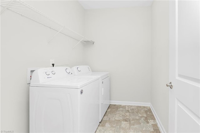 clothes washing area featuring washing machine and dryer and light tile patterned floors