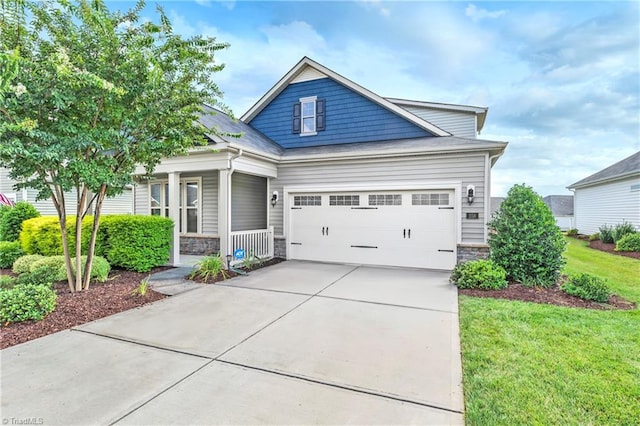 craftsman inspired home featuring a garage and a front lawn