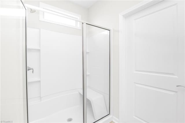 bathroom with a shower with door