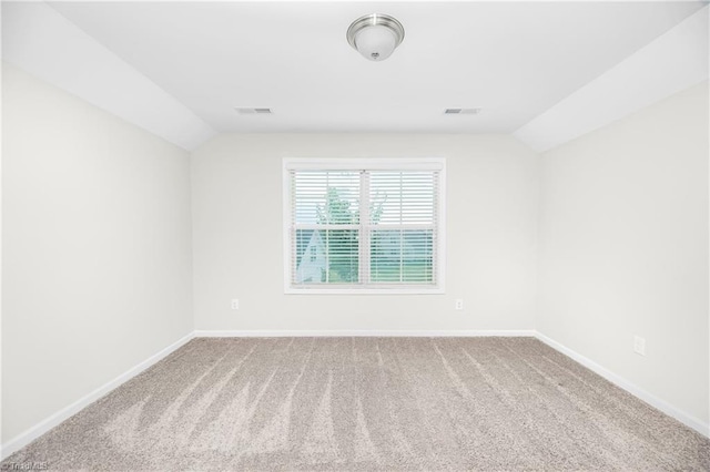 carpeted spare room featuring lofted ceiling