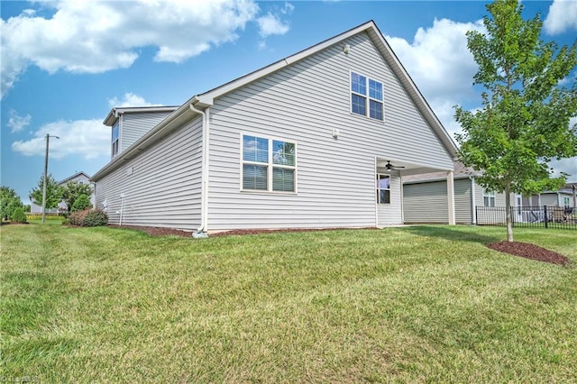 back of property with ceiling fan and a lawn