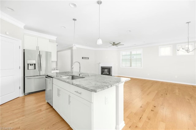 kitchen featuring crown molding, sink, light hardwood / wood-style floors, appliances with stainless steel finishes, and a kitchen island with sink