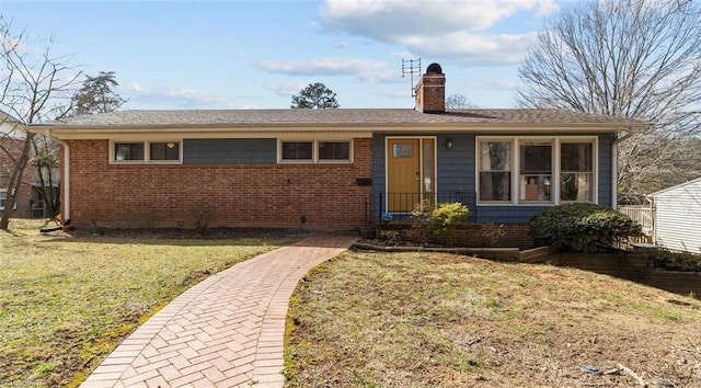 single story home featuring a front yard, a chimney, and brick siding