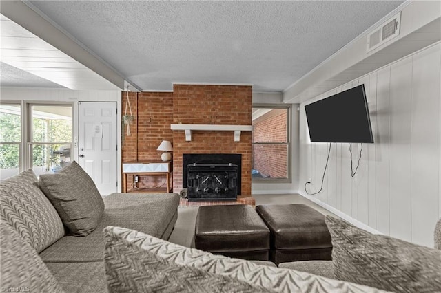 living area featuring visible vents, a fireplace, and a textured ceiling