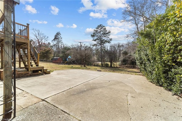 view of patio / terrace featuring stairs, a deck, a playground, and fence