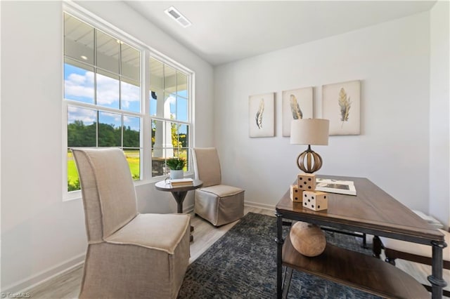 living area featuring light wood-style floors, baseboards, and visible vents