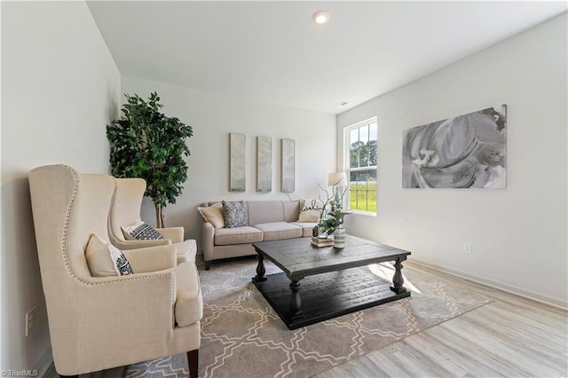 living area with recessed lighting, baseboards, and wood finished floors