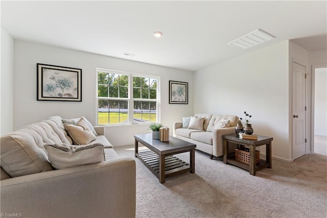 living room featuring visible vents, baseboards, and light carpet