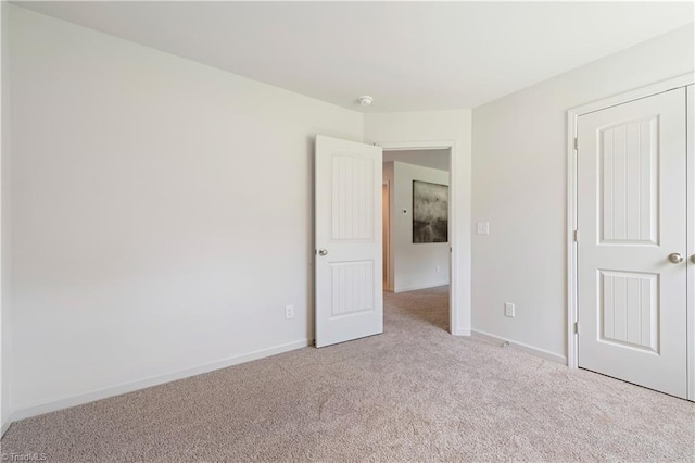 unfurnished bedroom featuring carpet floors and baseboards