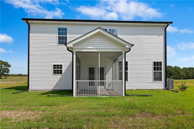 back of property featuring a sunroom, central AC, and a yard