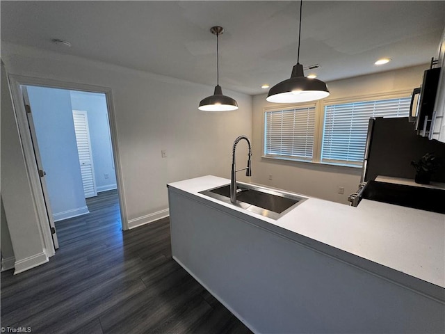 kitchen with sink, fridge, decorative light fixtures, dark hardwood / wood-style flooring, and kitchen peninsula