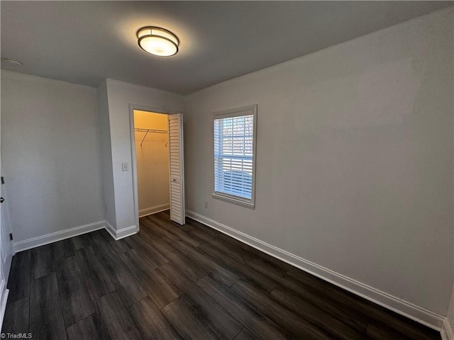 unfurnished bedroom with dark hardwood / wood-style floors and a closet