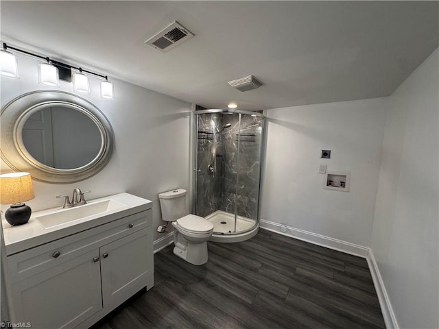 bathroom with hardwood / wood-style floors, vanity, toilet, and walk in shower