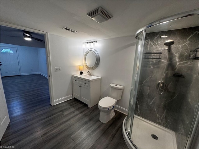 bathroom with vanity, hardwood / wood-style flooring, toilet, and a shower with door