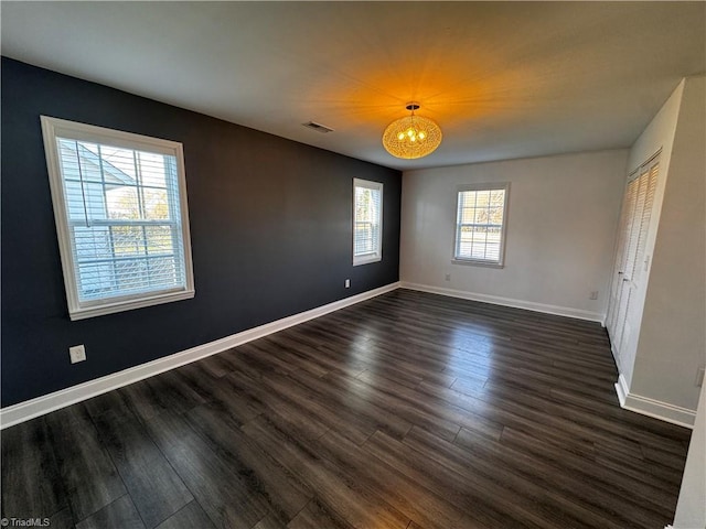 spare room with dark hardwood / wood-style flooring and plenty of natural light