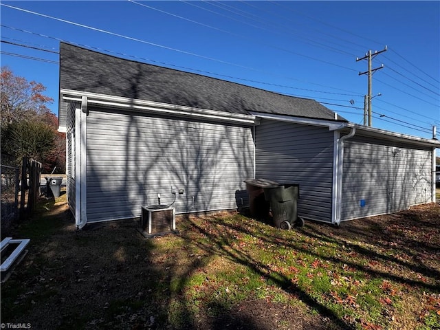 view of side of home featuring cooling unit and a lawn