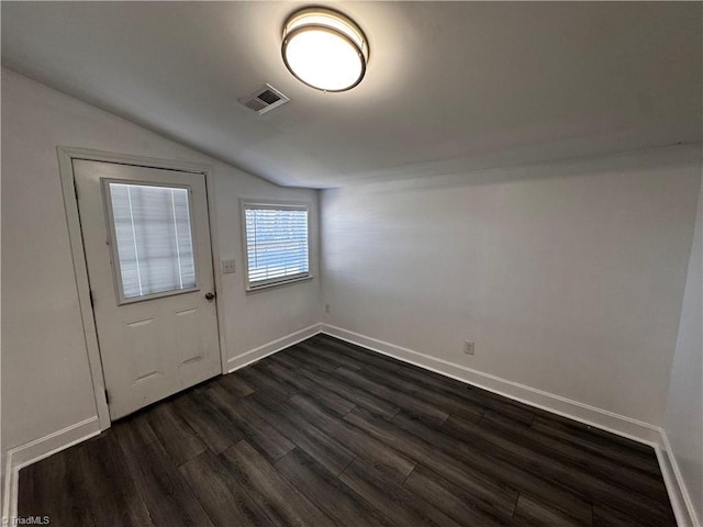 interior space with dark hardwood / wood-style flooring and vaulted ceiling