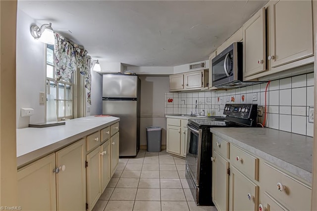 1401 Bretton St, Winston-Salem, NC 27105 - kitchen with stainless steel appliances, a sink, light countertops, decorative backsplash, and light tile patterned floors