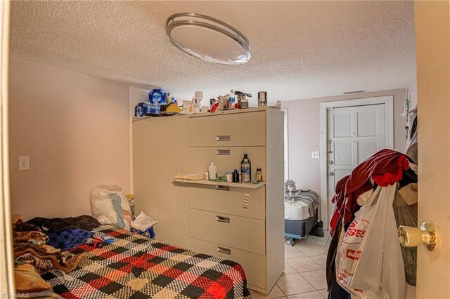 1401 Bretton St, Winston-Salem, NC 27105 - bedroom featuring light tile patterned flooring and a textured ceiling