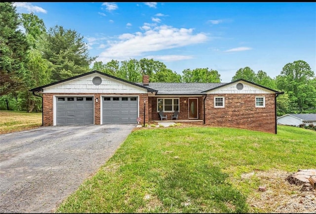 ranch-style house featuring driveway, a garage, and a front yard