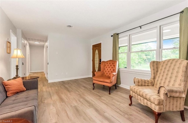 living area with light wood-type flooring and baseboards