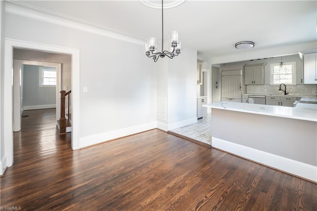 kitchen with decorative backsplash, plenty of natural light, and dark wood-type flooring