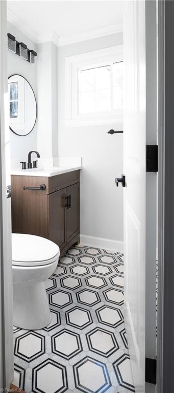 bathroom with vanity, toilet, a wealth of natural light, and ornamental molding